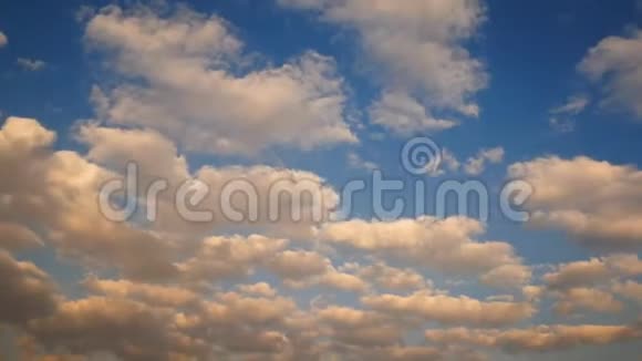 4太阳落山或日出时带有橙色云的白色浮肿飘过夏日蓝天的K片镜头相机拍动视频的预览图