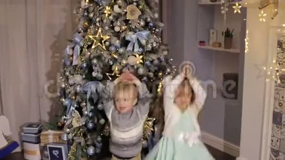 两个孩子在圣诞树附近跳视频的预览图