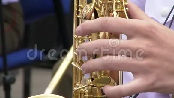 穿着夹克的萨克斯演奏家在金色萨克斯管上演奏现场表演爵士乐视频的预览图