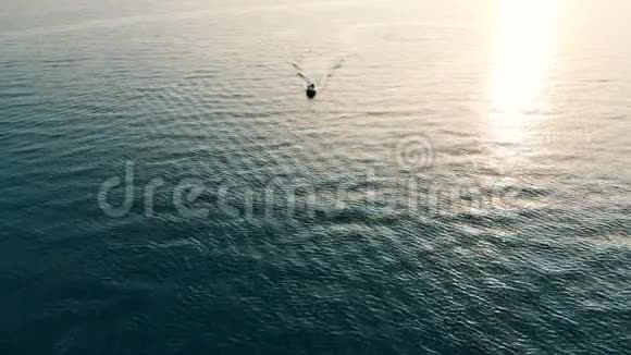 一艘快艇漂浮在开阔的水面上日落时分出海视频的预览图