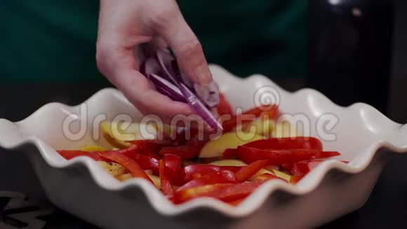 厨师用红洋葱和其他蔬菜做饭菜厨师在饭菜中加入洋葱辛辣的素食和美食视频的预览图
