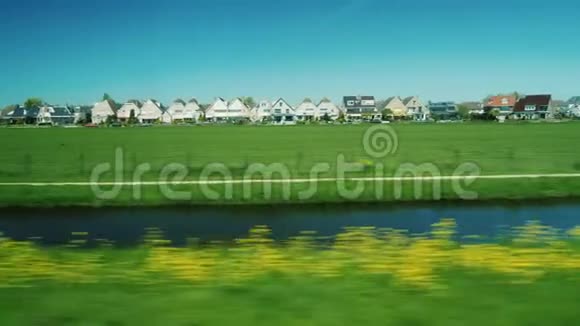 沿着荷兰风景优美的地形走古老的木屋草地和从窗户看到的运河视频的预览图