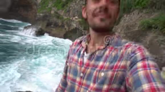 男子在美丽的风景附近自拍照片海浪视频的预览图