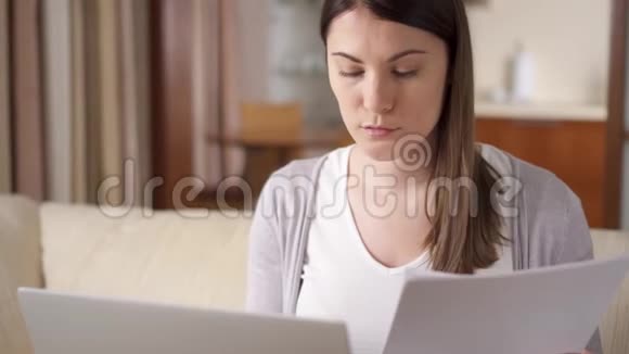 迷人的微笑专业的年轻女性在家工作拿着文件家庭办公概念视频的预览图