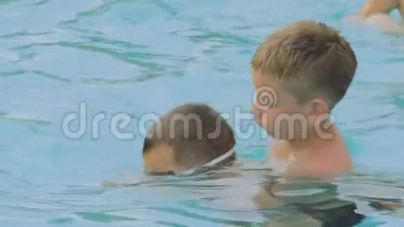男孩教孩子在游泳池里潜水视频的预览图