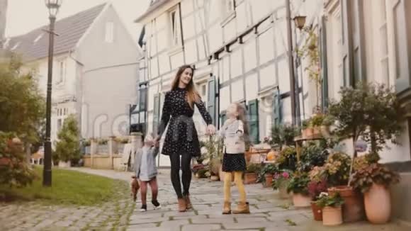 美丽的女人带着两个孩子走路牵着手欧洲母亲女孩和男孩在一起哈廷根德国4K视频的预览图