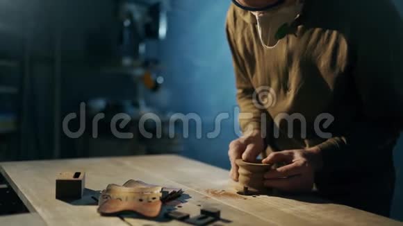 一名男子正在用旋转的销钉在木制工作表面上加工木坯视频的预览图