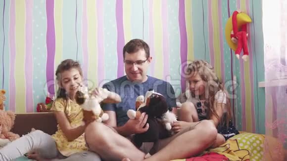 一位年轻的父亲和他的女儿在孩子们房间里玩洋娃娃视频的预览图