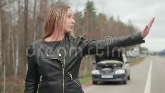 年轻的棕色头发的女人在破机器附近停下来兜风视频的预览图