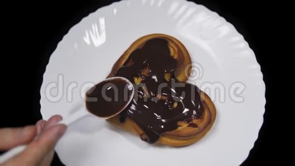 有人把巧克力倒在一个甜美的心形面包上视频的预览图