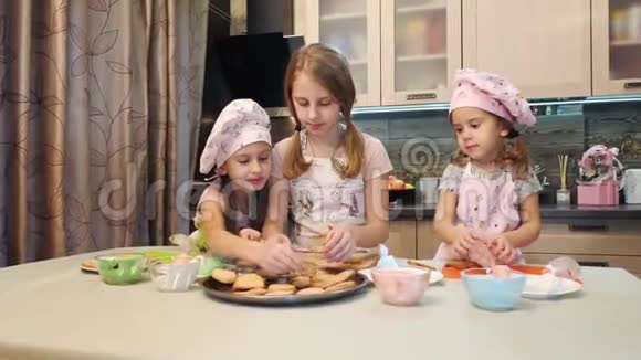三个可爱的女孩从盘子里拿出一块饼干视频的预览图