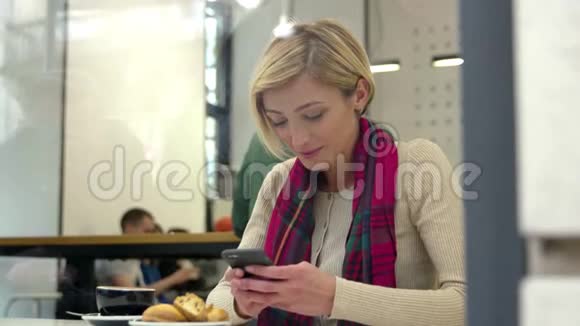 在咖啡厅喝咖啡和使用手机的女人视频的预览图