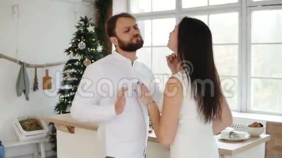 快乐迷人的年轻情侣在圣诞树旁的时髦公寓里一起跳舞可爱的小可爱视频的预览图