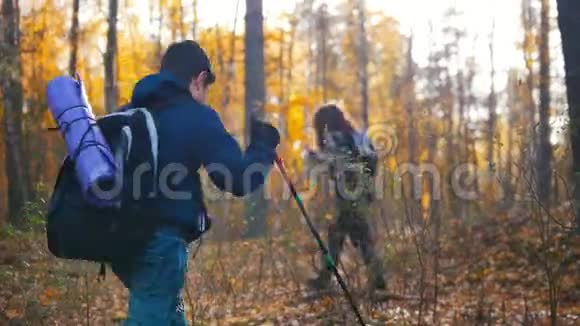 年轻的女人和一个徒步旅行的男孩斯堪的纳维亚人散步秋天从后面看视频的预览图