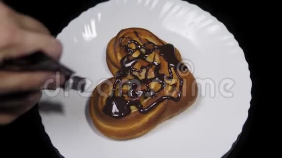 有人把巧克力倒在一个甜美的心形面包上视频的预览图