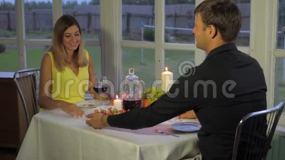 晚上快乐的夫妻共进浪漫晚餐手牵手夹眼镜视频的预览图