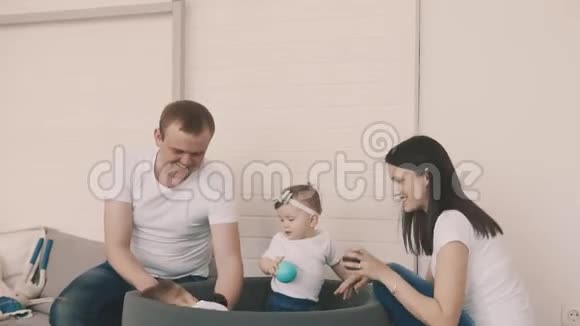 可爱的家庭在球池里玩耍妈妈爸爸儿子和女儿玩得开心视频的预览图