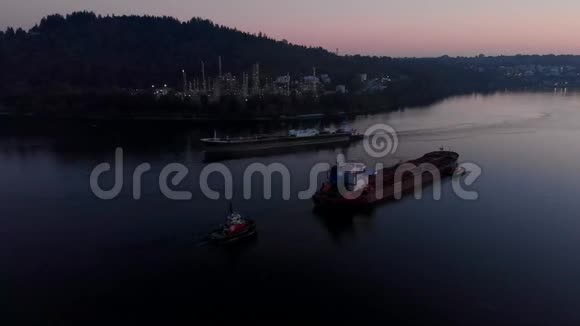 日落时分温哥华的伯拉德湾一艘货船被拖船推着视频的预览图