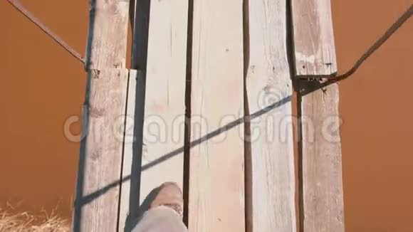人正在河上的一座悬空木桥上行走特写腿视频的预览图