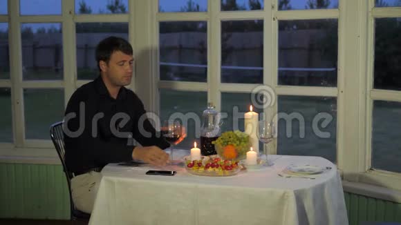 坐在餐桌前的男人喝红酒吃墨西哥菜呼唤服务员视频的预览图