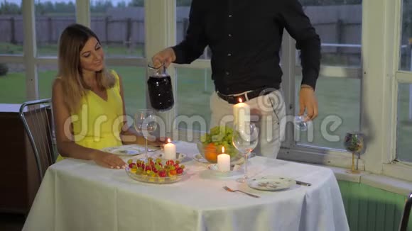 爱的夫妻在晚上为浪漫的晚餐男人送女人红酒视频的预览图