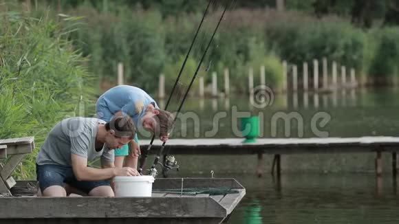 渔人在湖边钓鱼竿上钓鱼钩视频的预览图
