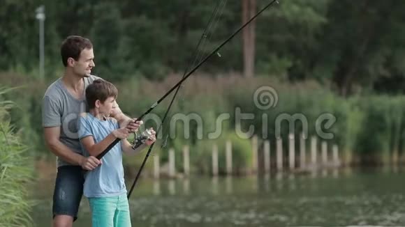 兴奋的儿子和父亲在池塘里钓鱼视频的预览图