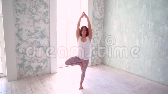快乐的年轻女人练习瑜伽健康活跃的生活方式理念女性在有自然光的工作室里做瑜伽视频的预览图