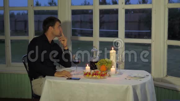 男人喜欢晚上的餐桌喝红酒看着派对等待视频的预览图