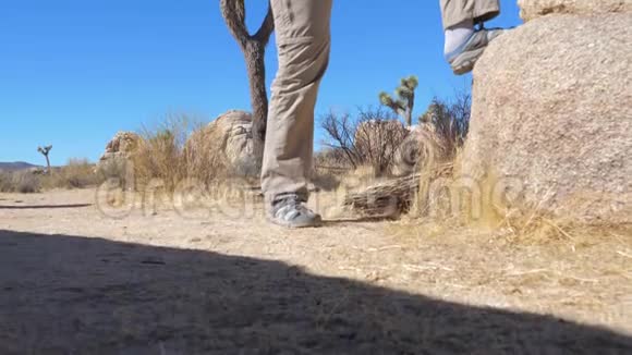 牛仔帽里的运动女人把脚放在石头上全景自下而上视频的预览图