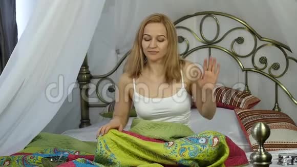 快乐年轻的女人醒来在家里的床上跳舞慢动作视频的预览图