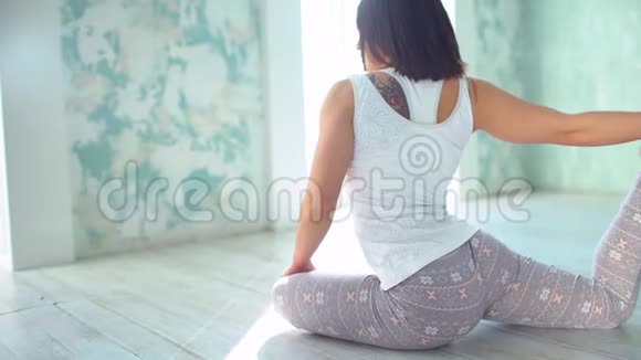 瑜伽垫女人伸展臀部腿筋肌肉腿部肌肉用鸽子姿势伸展20岁视频的预览图