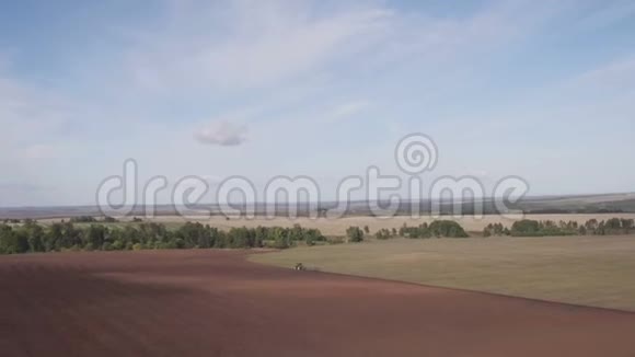 拖拉机耕地用拖拉机鸟瞰收获田耕地农业机械视频的预览图