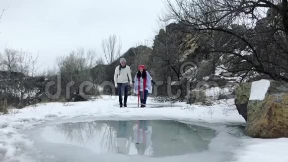 年轻夫妇在公园里玩得很开心骑在结冰的水坑上水被融化了慢动作视频的预览图