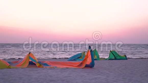 五颜六色的训练风筝躺在沙滩上背景是黎明的鸟儿在飞翔视频的预览图