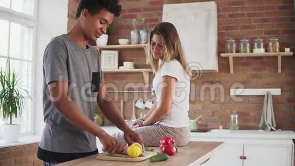 英俊的非洲男人准备沙拉切柠檬用有趣的方式榨果汁而他的白种人视频的预览图