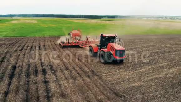 健康食品生产理念拖拉机正在播撒一片有种子的宽敞草地空中飞行视频的预览图