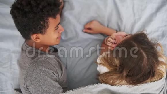 幸福的多种族夫妇躺在床上聊天的最高景观有魅力的年轻男女相爱浪漫主义概念视频的预览图