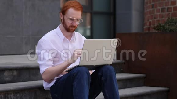 穿着笔记本电脑坐在靠窗的地方时设计设计师的思考视频的预览图