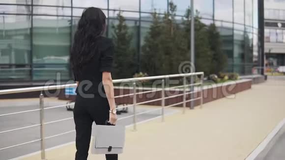 年轻自信的商界女性的肖像手里拿着文件夹一个穿着裤子的女孩走了下来视频的预览图