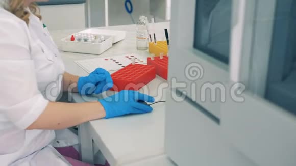 带血的管子在离心机中检查而实验室工作人员则在电脑中工作视频的预览图