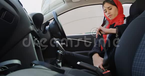 戴头巾的女人在车里系安全带视频的预览图
