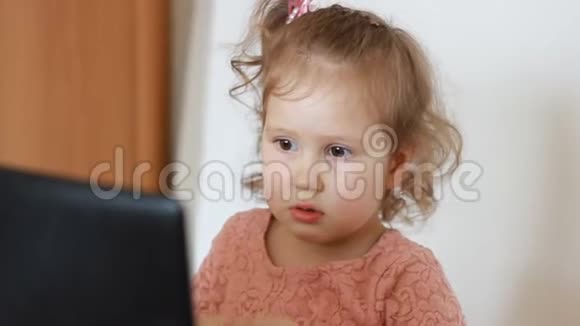 童女衣耳机并看屏幕监控电脑视频的预览图