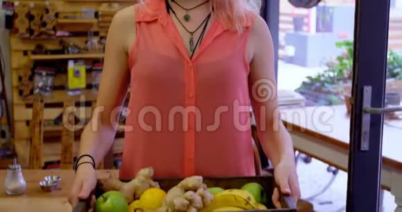 女人拿着装满蔬菜和水果的托盘视频的预览图