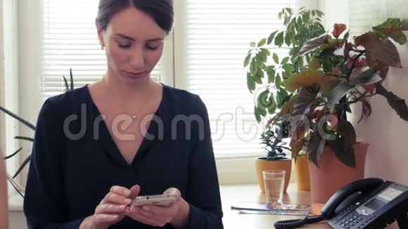 坏消息一个年轻漂亮的女人对她的智能手机上的短信感到烦恼和压力视频的预览图