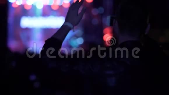 夜总会的气氛男人在电话里拍视频在音乐会上挥舞双手视频的预览图