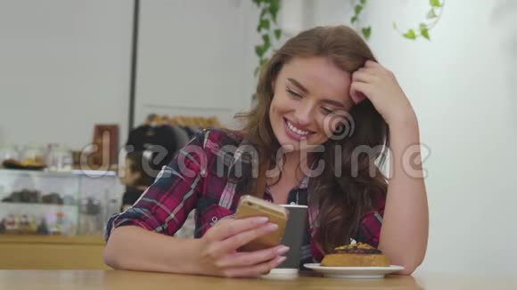 微笑的女人用手机喝咖啡视频的预览图