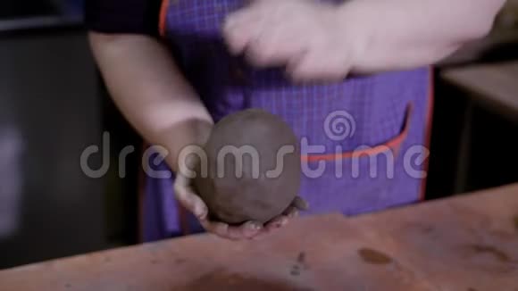 一位陶艺大师的手用粘土捏成了一个大球近距离拍摄视频的预览图