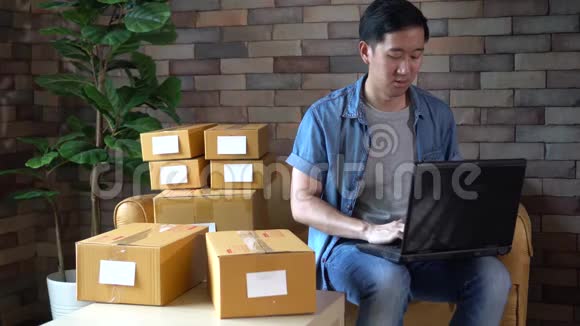 亚洲男性企业家在家使用笔记本电脑和盒装视频的预览图