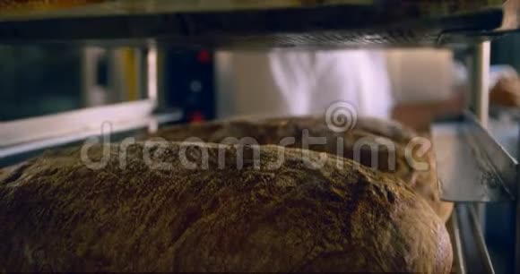 厨师把烤好的面包放在架子上视频的预览图